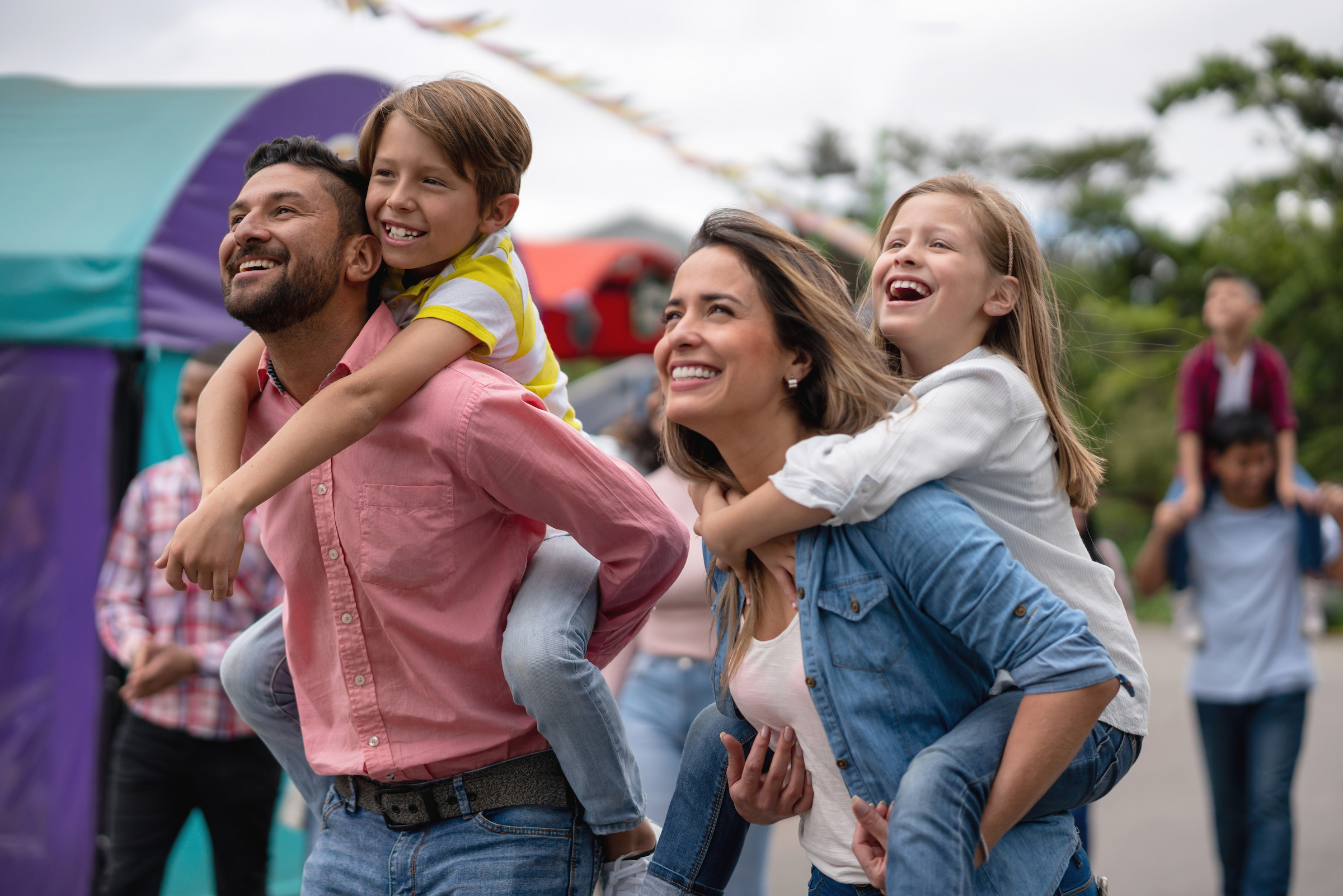 Family with two small kids smiling.